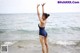 A woman in a blue bathing suit standing in the ocean.