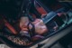 A woman laying in the back seat of a car holding a book.