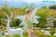 A woman in a green dress standing next to a white deer.