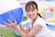 A young woman holding a large blue and white ball.