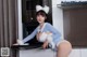 A woman in a bunny costume is posing in the kitchen.