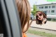 A woman is looking in the rear view mirror of a car.