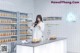 A woman in a lab coat standing in front of a counter.